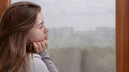 Depressione stagionale: donna triste davanti alla finestra 