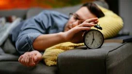 risveglio Uomo fa fatica a risvegliarsi dopo aver dormito tutta la notte con la tv accesa.